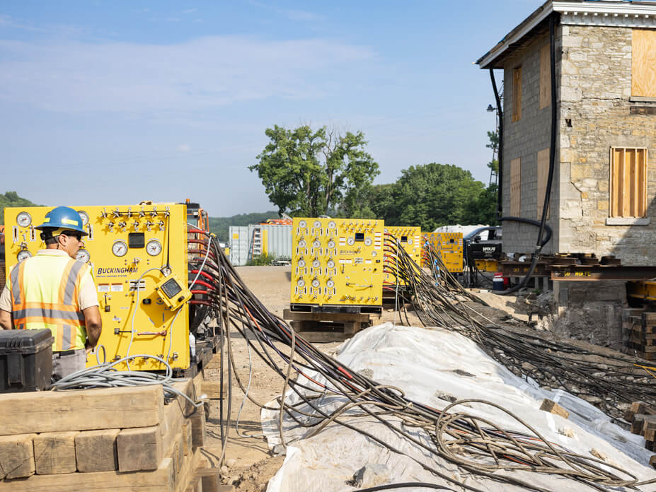 Close-up shot of unified jacking machines with worker in foreground