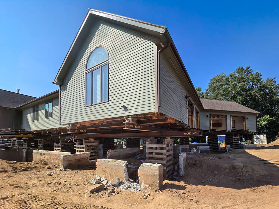 Single story home and garage sits on steel and cribbing for foundation replacement