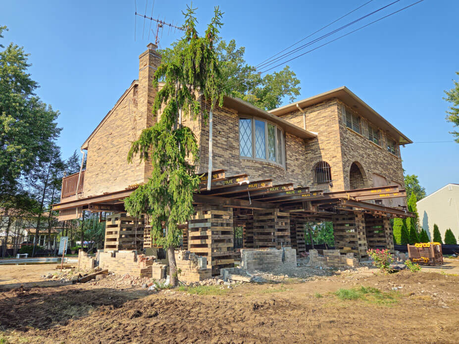 New Jersey house lift shows house on cribbing with old foundation walls under it