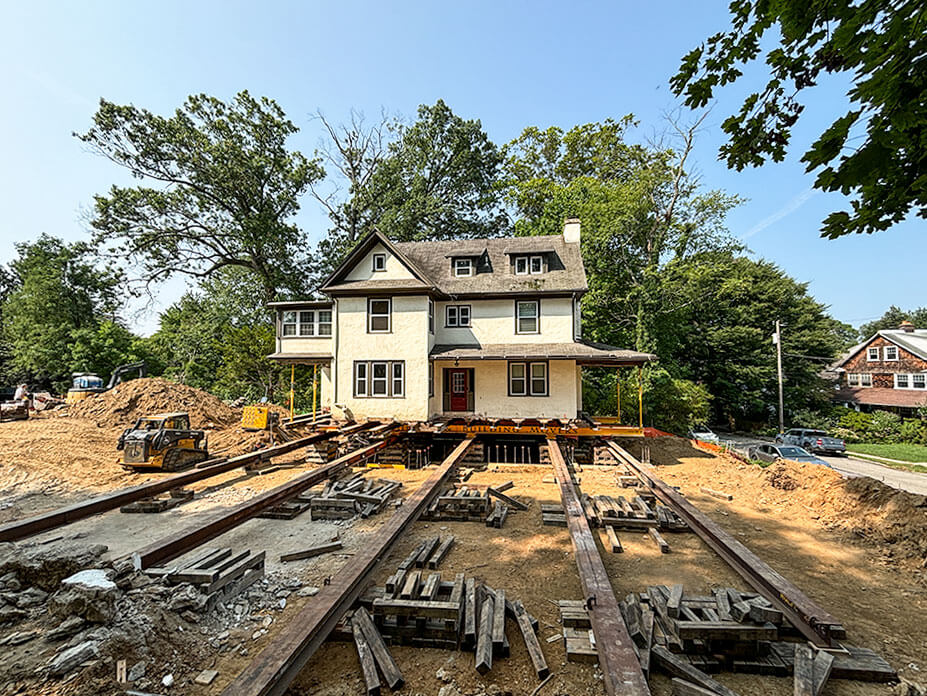 Roll beams and cribbing in foreground with house on rollers in background