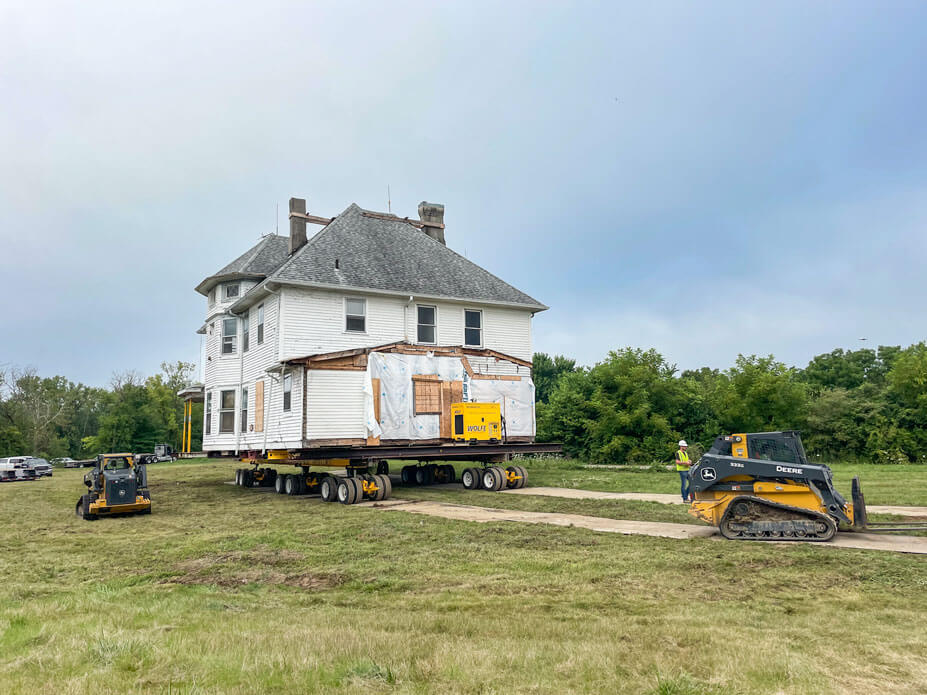 White house drives across lawn as skid steers lay out steel plate in front of it