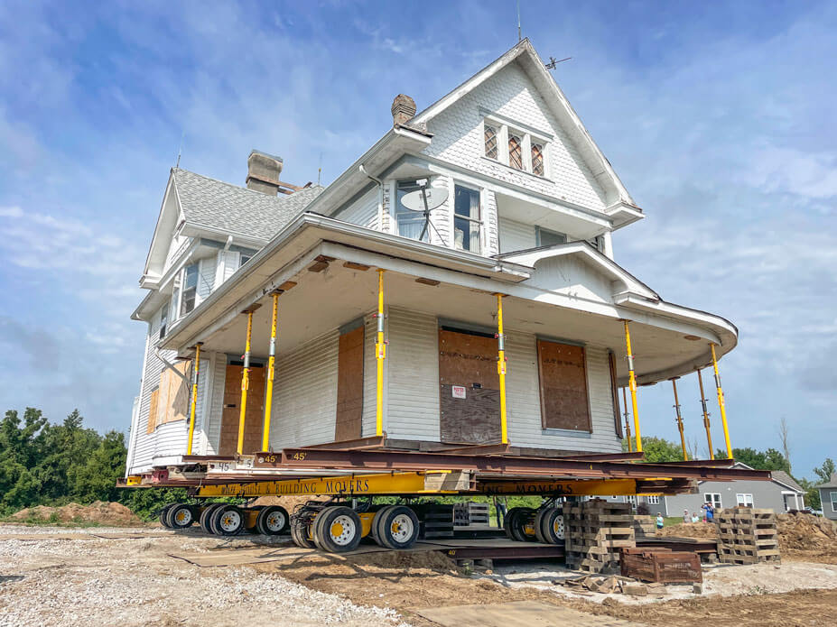 White historic house sits on Wolfe steel beams and dollies on its new foundation