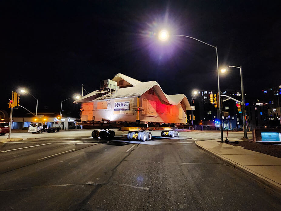 Nighttime view of Wolfe moving bungalow down street with streetlamp in foreground