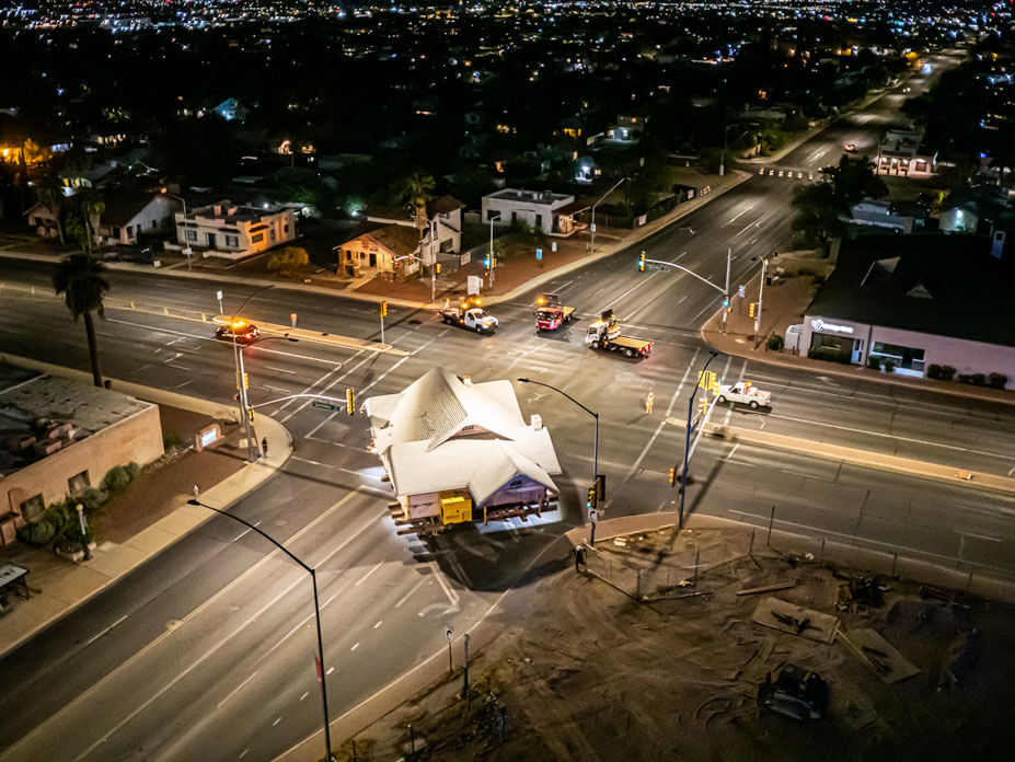 Aerial view of Wolfe moving a Tucson bungalow around a street corner